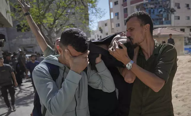 A man kisses the body of a victim of an Israeli army strike on a restaurant, which killed at least 29 people, as he is taken from the scene to the Shifa hospital in Gaza City, Wednesday, May 7, 2025.(AP Photo/Jehad Alshrafi)