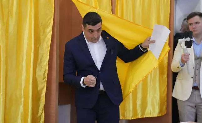 Presidential candidate George Simion exits a voting booth before casting his vote in the first round of the presidential election redo in Bucharest, Romania, Sunday, May 4, 2025. (AP Photo/Vadim Ghirda)
