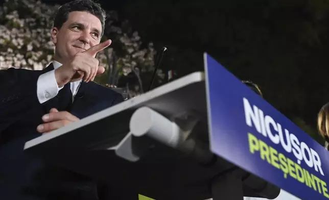 Presidential candidate Nicusor Dan gestures as he addresses supporters after polls closed for the first round of the country's presidential election redo in Bucharest, Romania, Sunday, May 4, 2025. (AP Photo/Eduard Vinatoru)