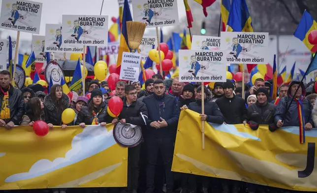 FILE - George Simion, center, presidential candidate for the Alliance for the Union of Romanians (AUR) stands during a protest calling for the resignation of the country's Prime Minister Marcel Ciolacu in Bucharest, Romania, Saturday, March 1, 2025. (AP Photo/Vadim Ghirda, File)