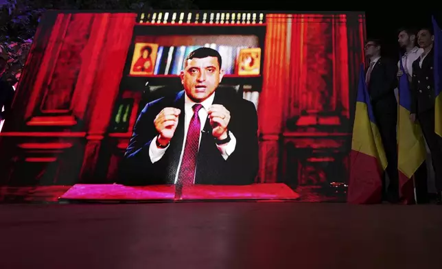 Presidential candidate George Simion is shown on a screen at the meeting of his supporters after polls closed for the first round of the country's presidential election redo in Bucharest, Romania, Sunday, May 4, 2025. (AP Photo/Andreea Alexandru)