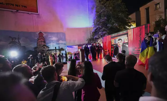 Presidential candidate George Simion is shown on a screen at the meeting of his supporters after polls closed for the first round of the country's presidential election redo in Bucharest, Romania, Sunday, May 4, 2025. (AP Photo/Andreea Alexandru)