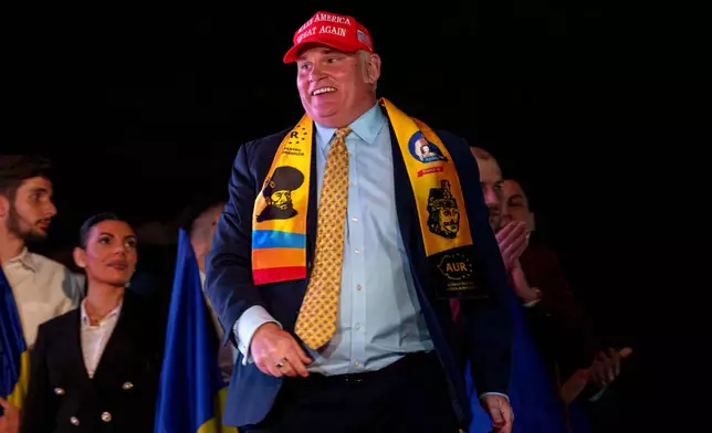 U.S. activist Brian Brown walks on stage as supporters of Presidential candidate George Simion celebrate the exit poll results outside the headquarters of the Alliance for the Unity of Romanians (AUR) after polls closed for the first round of the country's presidential election redo in Bucharest, Romania, Sunday, May 4, 2025. (AP Photo/Andreea Alexandru)