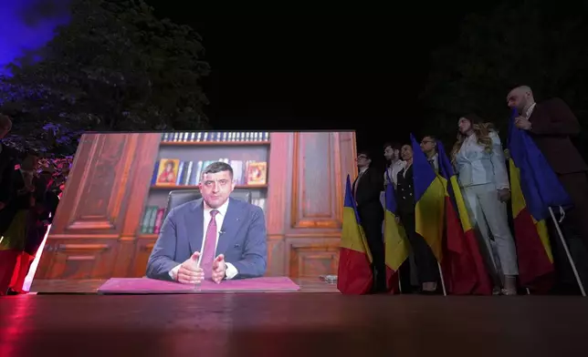 Presidential candidate George Simion is shown on a screen at the meeting of his supporters after polls closed for the first round of the country's presidential election redo in Bucharest, Romania, Sunday, May 4, 2025. (AP Photo/Andreea Alexandru)