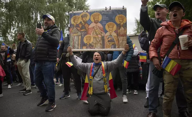 Supporters of Calin Georgescu, the winner of the first round of last year's annulled election, chant slogans during his appearance at a prosecutor's office in Bucharest, Romania, Tuesday, May 27, 2025. (AP Photo/Vadim Ghirda)