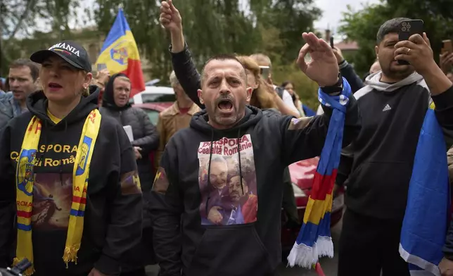 Supporters of Calin Georgescu, the winner of the first round of last year's annulled election, chant slogans during his appearance at a prosecutor's office in Bucharest, Romania, Tuesday, May 27, 2025. (AP Photo/Vadim Ghirda)