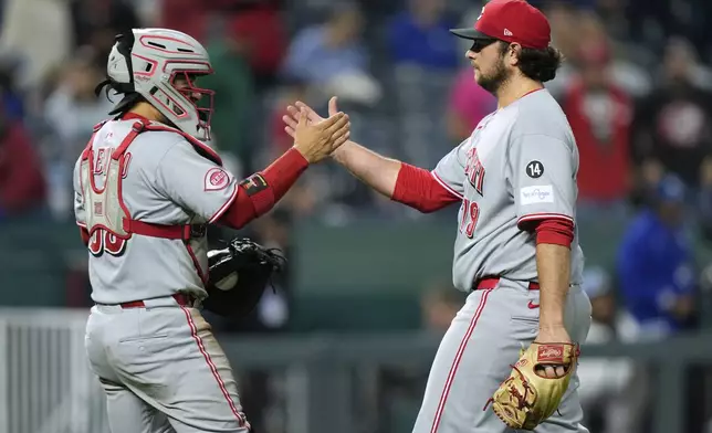 Cincinnati Reds relief pitcher Ian Gibaut, right, and catcher Jose Trevino celebrate after their baseball game against the Kansas City Royals, Tuesday, May 27, 2025, in Kansas City, Mo. (AP Photo/Charlie Riedel)