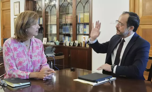 U.N. chief's personal envoy for Cyprus, Maria Angela Holguin Cuellar, left, and Cyprus' President Nikos Christodoulides talk during their meeting at the Presidential Palace in the divided capital Nicosia, Cyprus, on Saturday, May 24, 2025. (AP Photo/Petros Karadjias)