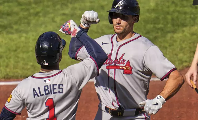 Atlanta Braves' Matt Olson, right, is greeted by Ozzie Albies (1) as he returns to the dugout after hitting a solo home run off Pittsburgh Pirates pitcher Andrew Heaney during the third inning of a baseball game in Pittsburgh, Saturday, May 10, 2025. (AP Photo/Gene J. Puskar)