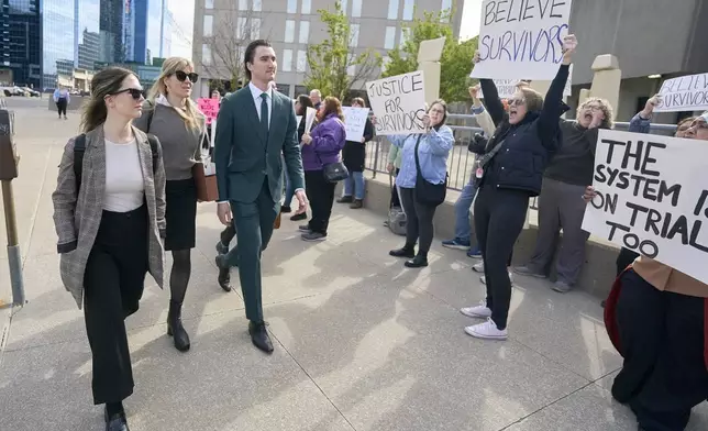Alex Formenton, one of five hockey players charged with sexual assault, passes protestors as he arrives at the courthouse in London, Ontario, Thursday, May 8, 2025. (Geoff Robins/The Canadian Press via AP)
