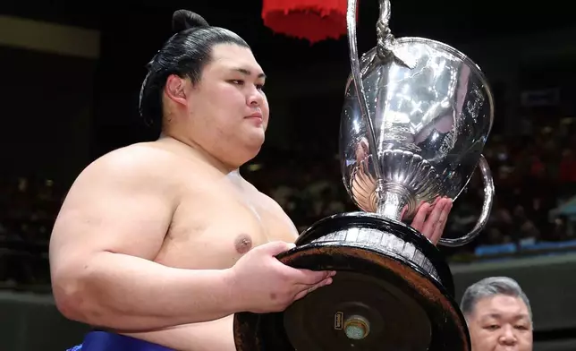 Onosato receives the trophy after winning in a sumo wrestling tournament at Ryogoku Kokugikan arena in Tokyo, Sunday, May 25, 2025. (Kyodo News via AP)
