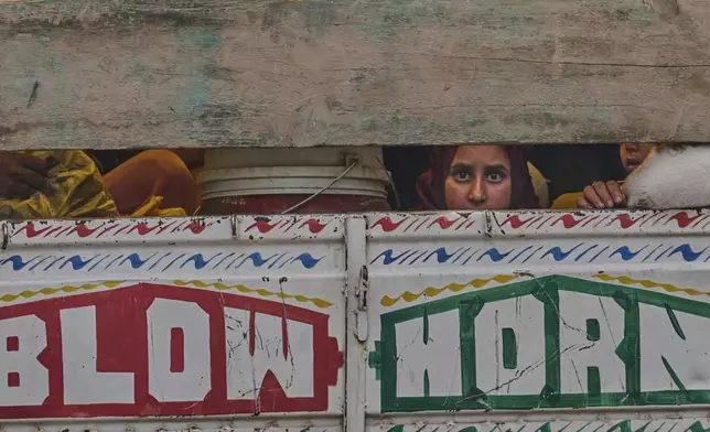 A Kashmiri woman looks from a truck as she along with her family members leave their village following overnight shelling from Pakistan at Gingal village in Uri district, Indian controlled Kashmir, Friday, May 9, 2025. (AP Photo/Dar Yasin)