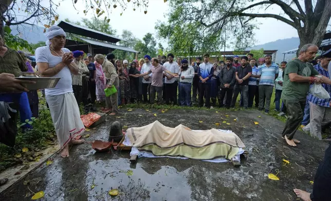 Sanjeev Barghava, left, performs the last rites of his son Vihaan Barghava, 13, killed in Pakistani artillery shelling in Poonch along the Line of Control, Indian controlled Kashmir, Thursday, May 8, 2025. (AP Photo/Channi Anand)
