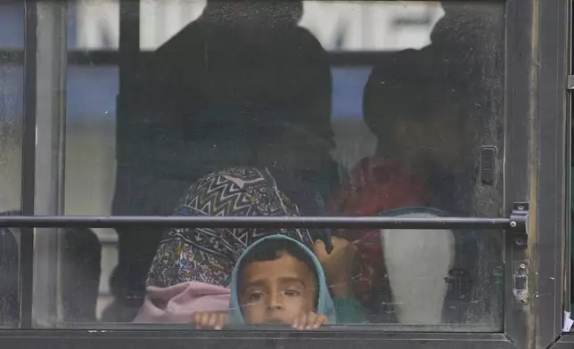 A Kashmiri village boy looks out of the window of a bus after they evacuated their village following overnight shelling from Pakistan at Gingal village in Uri district, Indian controlled Kashmir, Friday, May 9, 2025. (AP Photo/Dar Yasin)