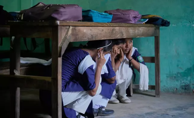 School students participate in a mock drill trained by civil defence members to respond in case of attack in Guwahati, India, Saturday, May 10, 2025 amid rising fears of wider conflict following India's strikes in Pakistan. (AP Photo/Anupam Nath)