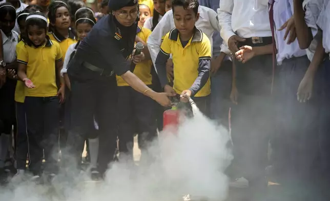 A civil defense official participates in a mock drill to train school students to respond in case of attack in Guwahati, India, Saturday, May 10, 2025 amid rising fears of wider conflict following India's strikes in Pakistan. (AP Photo/Anupam Nath)