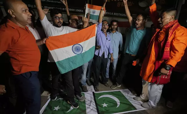People stand over Pakistani flags and holding Indian national flags chant slogans in favor of the Indian Army as they celebrate the success of 'Operation Sindoor', in Guwahati, India, Thursday, May 8, 2025. (AP Photo/Anupam Nath)