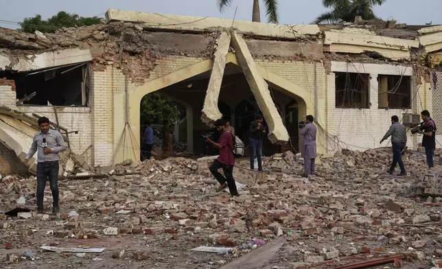 Members of media photograph the rubble of a mosque building damaged by Indian missile attack, in Muridke, a town in Pakistan's Punjab province, Wednesday, May 7, 2025. (AP Photo/K.M. Chaudary)