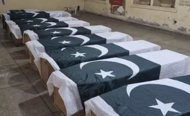 Caskets wrapped in national flags, hold the victims of an Indian missile attack, are placed for funeral services in Bahawalpur, Pakistan's Punjab province, Wednesday, May 7, 2025. (AP Photo/Asim Tanveer)