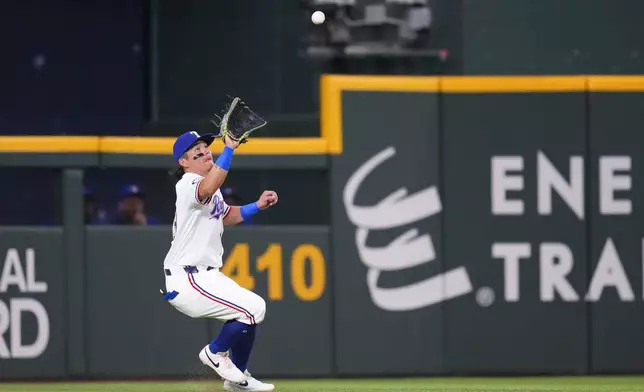 Texas Rangers outfielder Alejandro Osuna makes a catch on a ball hit by the Toronto Blue Jays during the second inning of a baseball game Tuesday, May 27, 2025, in Arlington, Texas. (AP Photo/Julio Cortez)
