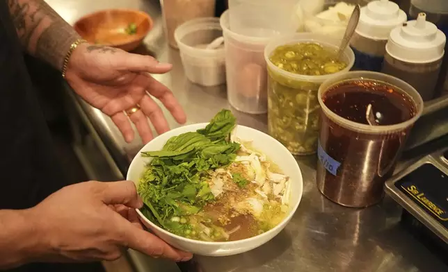 Chef Phila Lorn holds a bowl of the The Mawn Noodle soup at his restaurant, Mawn, in Philadelphia, Thursday, May 22, 2025. (AP Photo/Matt Rourke)