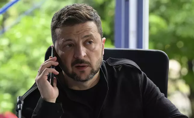 Ukraine's President Volodymyr Zelensky speaks on the phone during a meeting at the European Political Community summit in Skanderbeg Square in Tirana, Albania, on Friday, May 16, 2025. (Leon Neal/Pool via AP)
