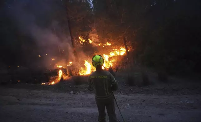 An Israeli firefighter works as forest fire is burning near Jerusalem, Wednesday, April 30, 2025. (AP Photo/Ohad Zwigenberg)