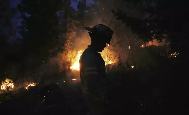 An Israeli firefighter works as forest fire is burning near Jerusalem, Wednesday, April 30, 2025. (AP Photo/Ohad Zwigenberg)