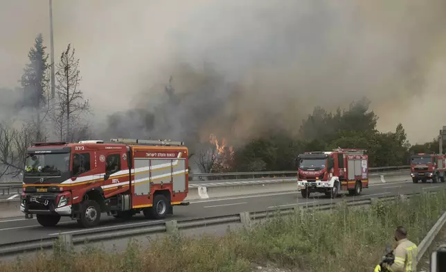 Firefighters work to extinguish a forest fire burning on a freeway to Jerusalem, Wednesday, April 30, 2025. (AP Photo/Mahmoud Illean)