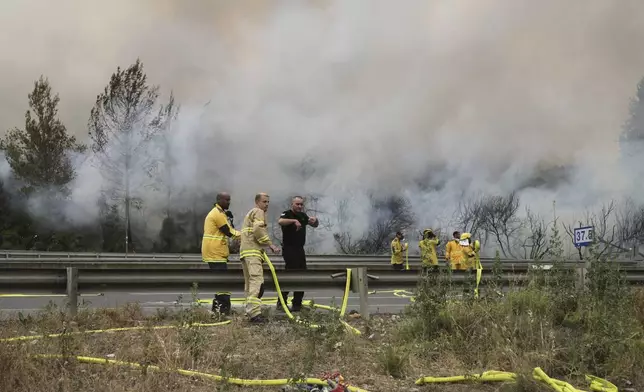 Firefighters work to extinguish a forest fire burning on a freeway to Jerusalem, Wednesday, April 30, 2025. (AP Photo/Mahmoud Illean)