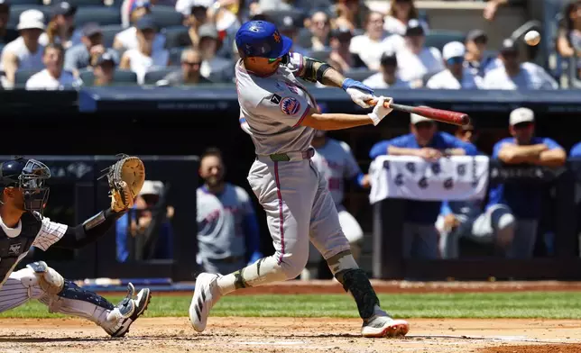 New York Mets' Mark Vientos (27) hits a sacrifice fly that that scored Juan Soto during the fourth inning of a baseball game against the New York Yankees, Saturday, May 17, 2025, in New York. (AP Photo/Noah K. Murray)