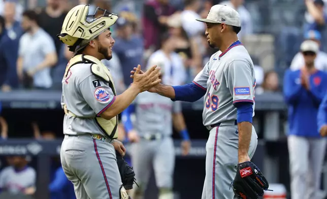 New York Mets catcher Luis Torrens (13) and pitcher Edwin Díaz (39) celebrate after defeating the New York Yankees following a baseball game, Saturday, May 17, 2025, in New York. (AP Photo/Noah K. Murray)