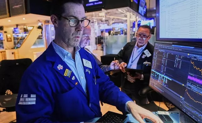 Specialist John McNierney, left, works with traders on the floor of the New York Stock Exchange, Thursday, May 29, 2025. (AP Photo/Richard Drew)