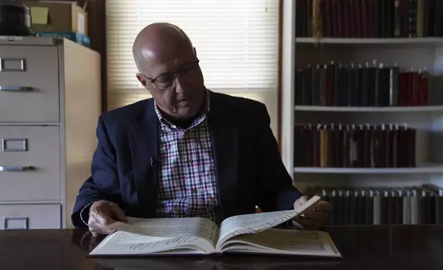 David Ivey, a longtime singer and chair of the Sacred Harp Publishing Company's revision and music committee, looks through "The Sacred Harp," shape-note songbook at the Sacred Harp Publishing Company and Museum in Carrollton, Ga., on Friday, March 21, 2025. (AP Photo/Jessie Wardarski)