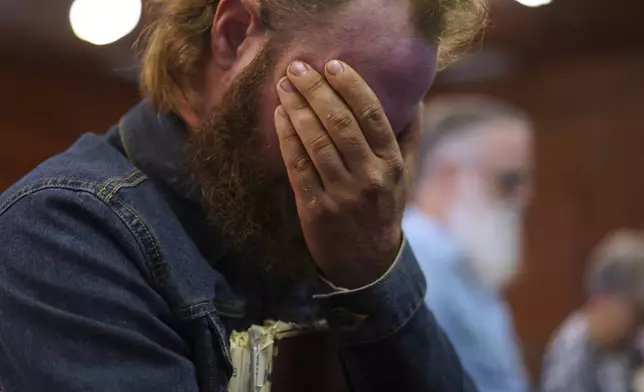 Isaac Green, 34, covers his eyes while praying before a Sacred Harp singing event at Holly Springs Primitive Baptist Church in Bremen, Ga., on Sunday, March 23, 2025. (AP Photo/Jessie Wardarski)