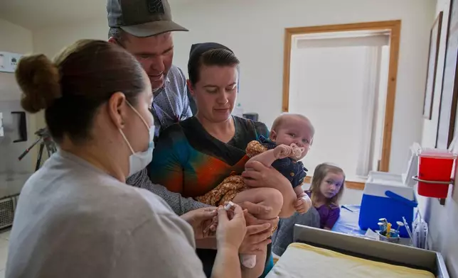 Mennonites Abraham Fehr and Katarina Wall hold their baby as he gets vaccinated weeks after the family fell sick with measles during an outbreak in Cuauhtemoc, Chihuahua state, Mexico, Thursday, May 1, 2025. (AP Photo/Megan Janetsky)