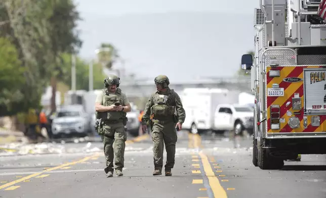 Sheriffs deputies walk near the scene of an explosion Saturday, May 17, 2025, in Palm Springs, Calif. (AP Photo/Eric Thayer)