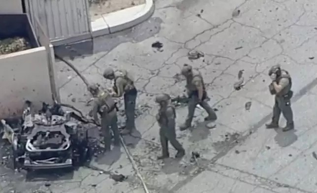 Law enforcement investigate a vehicle after an explosion on Saturday, May 17, 2025 in Palm Springs, Calif. (ABC7 Los Angeles via AP)