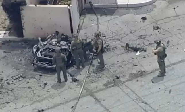 Law enforcement investigate a vehicle after an explosion on Saturday, May 17, 2025 in Palm Springs, Calif. (ABC7 Los Angeles via AP)