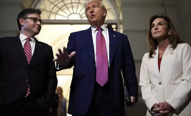 President Donald Trump, center, surrounded by Speaker of the House Mike Johnson, R-La., and Rep. Lisa McClain, R-Mich., speaks to reporters before a House Republican conference meeting, Tuesday, May 20, 2025, at the U.S. Capitol in Washington. (AP Photo/Julia Demaree Nikhinson)