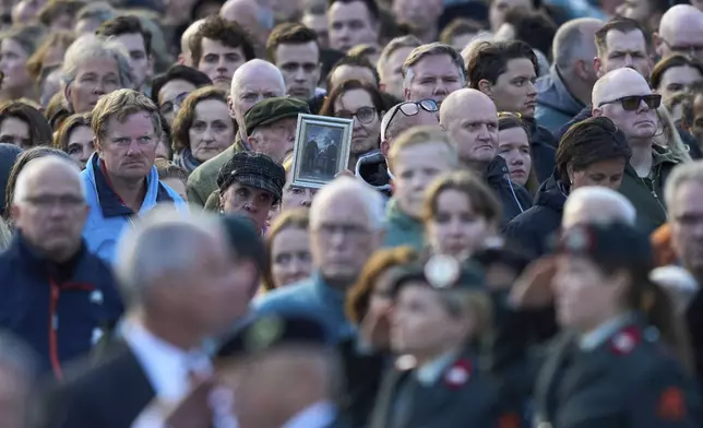A person holds a picture during a solemn annual national service to commemorate the war dead in Amsterdam, Netherlands, Sunday, May 4, 2025. (AP Photo/Peter Dejong)