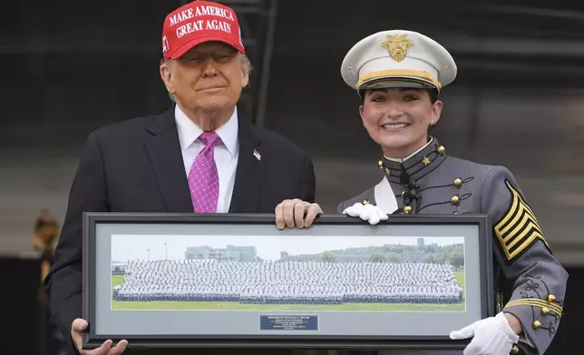 Class President Katherine LaReau, right, poses with President Donald Trump as she presents the class gift to Trump at the United States Military Academy commencement ceremonies in West Point, N.Y., Saturday, May 24, 2025. (AP Photo/Manuel Balce Ceneta)