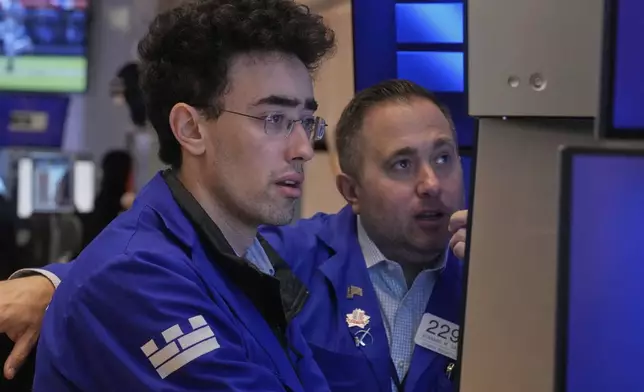 Specialists Alex Weitzman, left, and Gennaro Saporito work on the floor of the New York Stock Exchange, Thursday, May 1, 2025. (AP Photo/Richard Drew)
