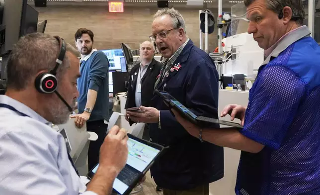 Phil Fracassini, center, works with fellow options traders on the floor of the New York Stock Exchange, Thursday, May 1, 2025. (AP Photo/Richard Drew)
