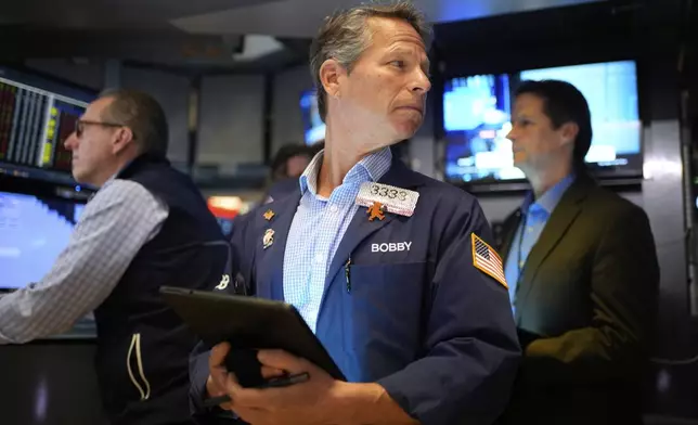 Bobby Charmak, center, works on the floor at the New York Stock Exchange in New York, Wednesday, April 30, 2025. (AP Photo/Seth Wenig)