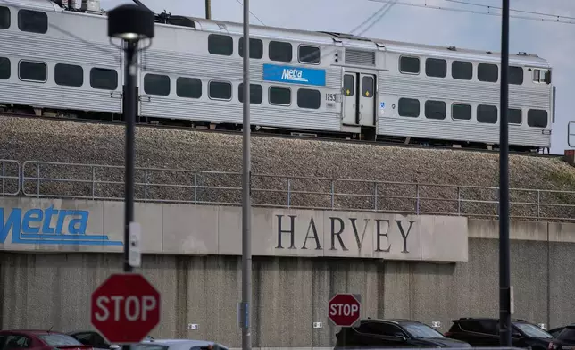 A Metra train leaves the station across from the Pace Harvey Transportation Center, Thursday, May 29, 2025, in Harvey, Ill. (AP Photo/Erin Hooley)