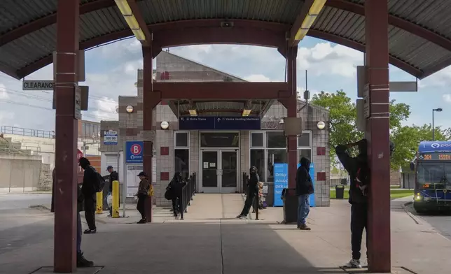 People wait at the Pace Harvey Transportation Center, Thursday, May 29, 2025, in Harvey, Ill. (AP Photo/Erin Hooley)