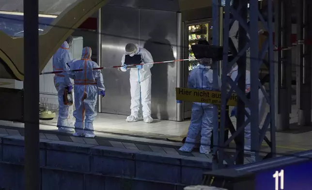 Investigators work at Hamburg, Germany's Central Station on Friday, May 23, 2025, after several people were injured in a knife attack. (Georg Wendt/dpa via AP)