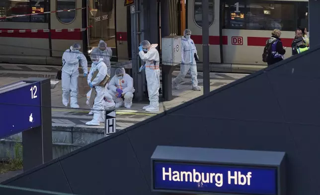 Police and forensics work near the crime scene after a stabbing attack at Hamburg Central Station, Friday, May 23, 2025, in Hamburg, Germany. (Georg Wendt/dpa via AP)