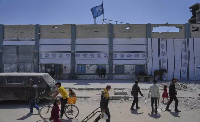 FILE - Palestinians walk next to the closed humanitarian aid distribution center of UNRWA, the U.N. agency helping Palestinian refugees in Jabaliya, Gaza Strip on Tuesday, April 29, 2025. (AP Photo/Jehad Alshrafi, File)